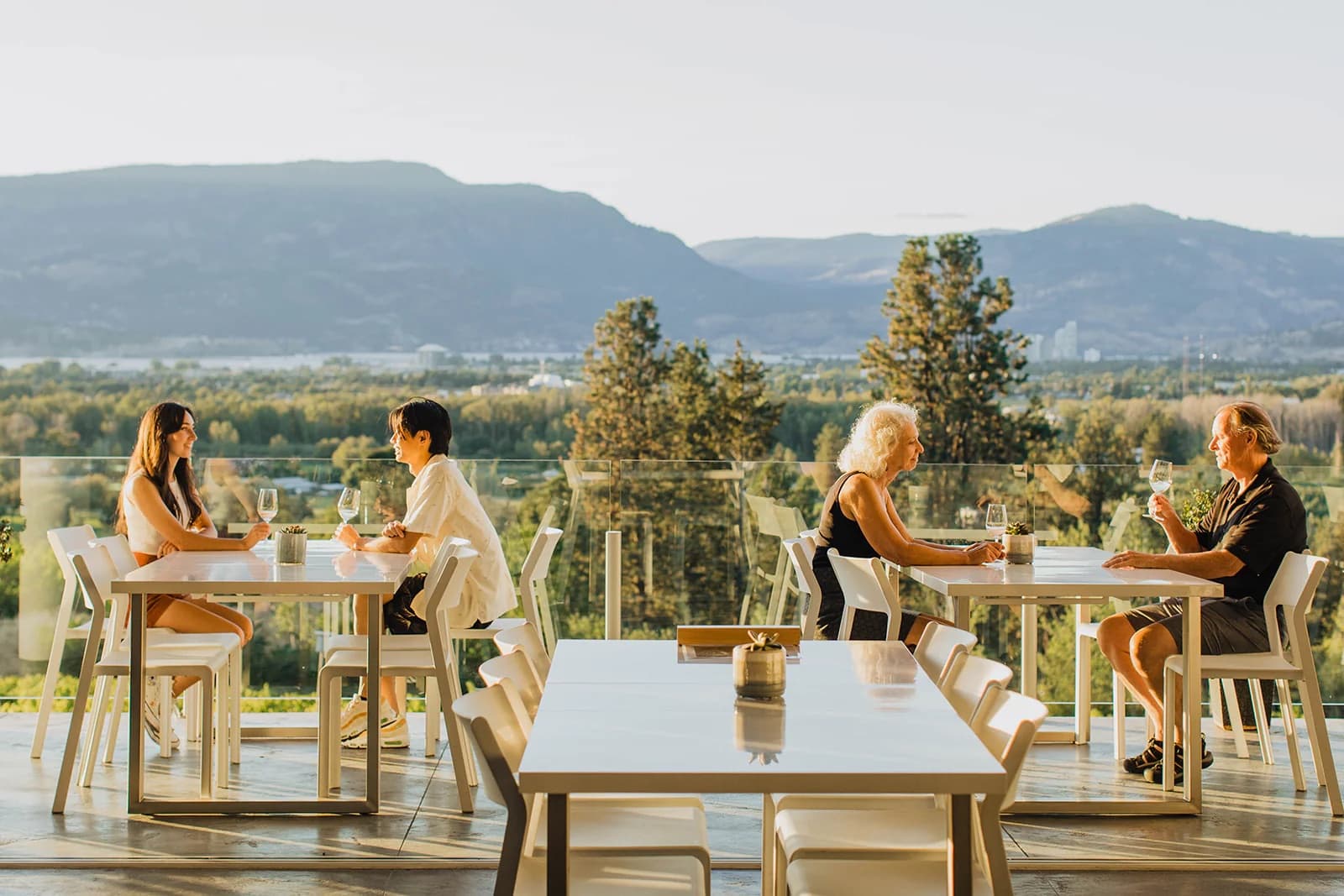 Guests wine tasting on the patio at Tantalus Winery, overlooking the Okanagan Valley