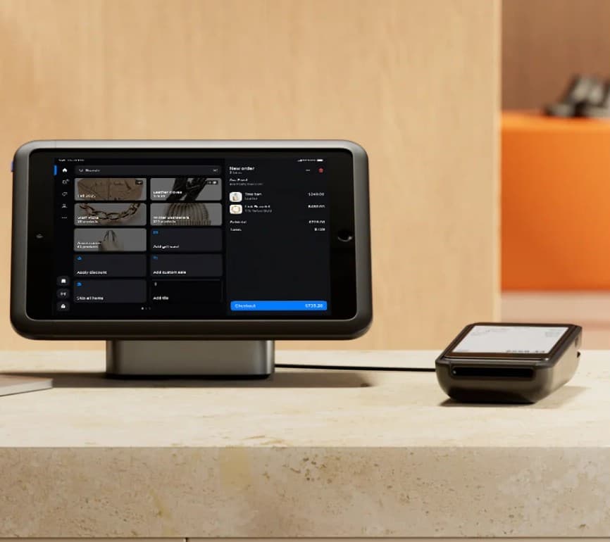Shopify POS stand and card reader on a store counter, running Team Shift